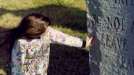 Girl Examining Message on Stones